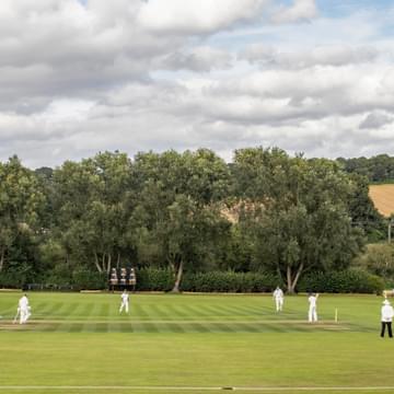 Cricket match with overcast clouds